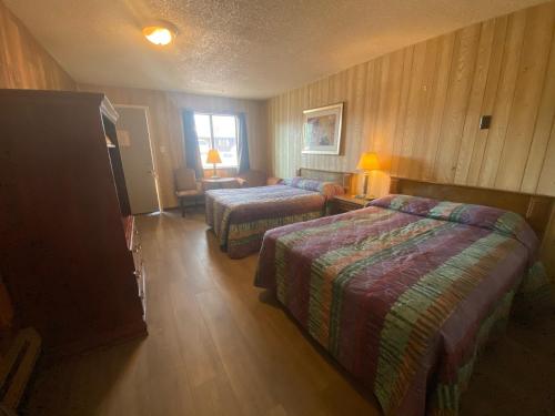 夏延Round-Up Motel的酒店客房带两张床、椅子和窗户