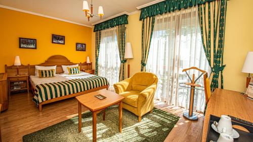 帕波Hotel Villa Classica的一间卧室配有一张床、一把椅子和一张桌子