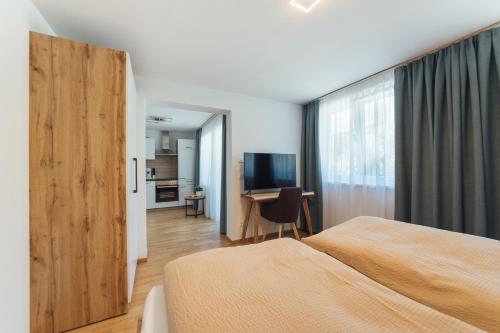 阿夫里茨Naturoase Appartements Mirnock的一间卧室配有一张床和一张书桌及电视