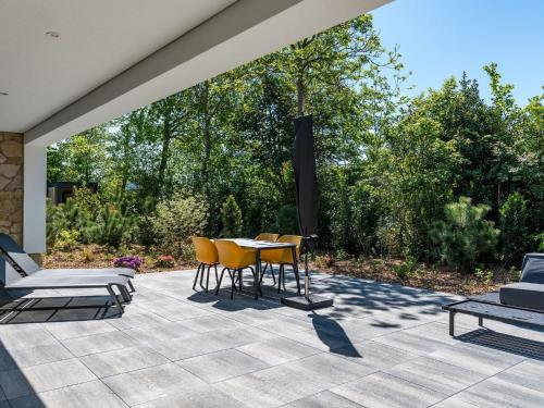 登堡Energy neutral villa with wellness area的庭院配有桌椅和树木
