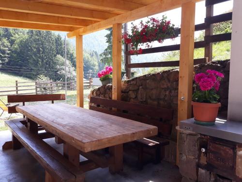 RevòLa quiete di Tregiovo - CIPAT 22253-AT-34903的鲜花庭院上的木餐桌
