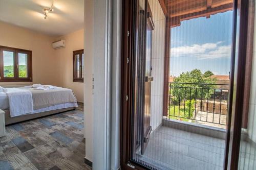 阿尔加拉斯蒂Villa Clairy in Argalasti, Pelion的一间卧室设有一张床和一个大窗户