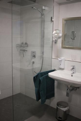 瓦尔德布勒尔Ferienwohnung zum Nutscheid的带淋浴、盥洗盆和镜子的浴室