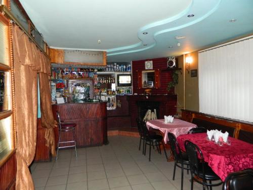 KhrystynivkaГотель АРГО的一间设有两张桌子的用餐室和一间酒吧