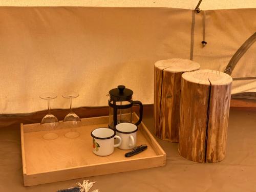 TromsiSaarjärve Puhkemaja Glämping的托盘,内配2杯咖啡和木凳