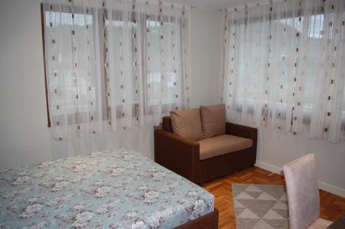 特里亚夫纳Апартамент Здравец的卧室配有床、椅子和窗户。