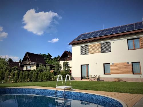 诺夫梅斯托纳马瑞夫Apartmán Svárov的一座带游泳池的房子和一座带太阳能电池板的房子