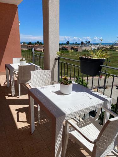 圣安杰洛城B&B Come a Casa的阳台上配有2张白色的桌椅,享有风景。
