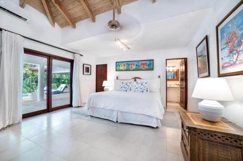 拉罗马纳Los Lagos 19- Golf and Lake View 5-Bedroom Villa的一间卧室配有一张床和一张带台灯的桌子