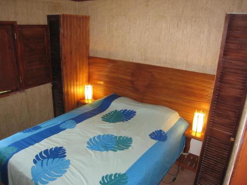 Faaone法尔艾里拉酒店的一间卧室配有一张带蓝色毯子的床