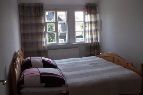NieskyWohnen im Holzhaus的卧室内的一张床位,带窗户