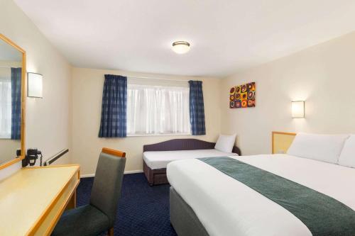 萨顿·斯科特尼戴斯萨顿斯科特尼南酒店的酒店客房配有两张床和一张书桌