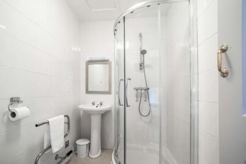 布莱克浦Comfort Inn Blackpool Gresham的带淋浴和盥洗盆的白色浴室