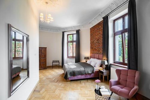 克拉科夫be HAPPY Apartments的一间卧室配有一张床、一把椅子和窗户。