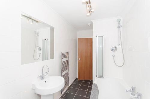 阿伯丁Aberdeen Quiet City Apartment, Ferryhill的白色的浴室设有水槽和淋浴。