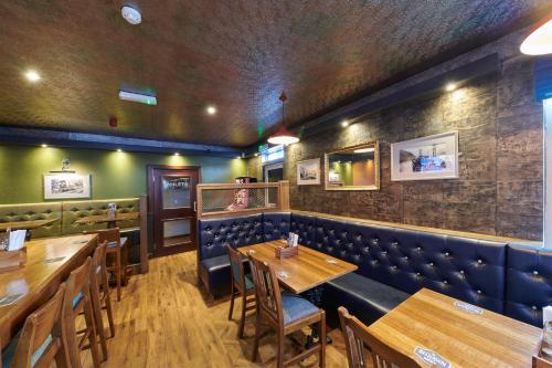 金洛赫利文Tailrace Inn的一间带木桌和蓝色展台的用餐室