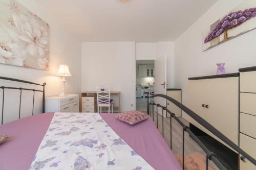 斯普利特Strawberry的一间卧室配有一张带紫色毯子的床