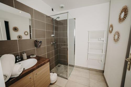 艾克斯莱班Charmant appartement 4 étoiles Bella Vita Zen的一间带水槽和玻璃淋浴的浴室