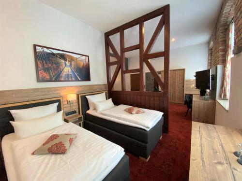 Artern弗雷德岑米特艾格纳弗莱斯彻雷酒店的一间酒店客房,设有两张床和电视