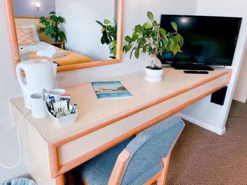阿宾汉姆拉特兰红翼汽车旅馆的一张桌子,房间里放有电视和植物
