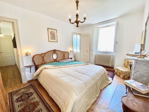 Pino Lago MaggioreCASA L'ARBI的一间卧室配有一张大床和一个吊灯。
