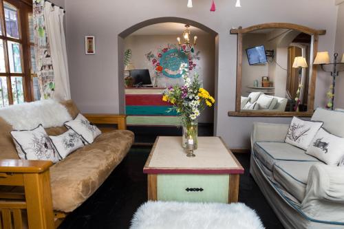 圣卡洛斯-德巴里洛切La Justina Hostel的客厅配有沙发和鲜花桌