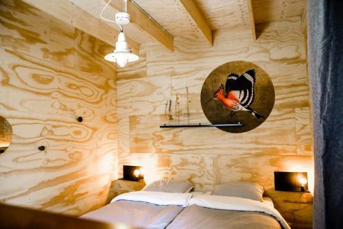 NesPean-buiten Waterlodges的卧室配有一张床,墙上挂着一个钟