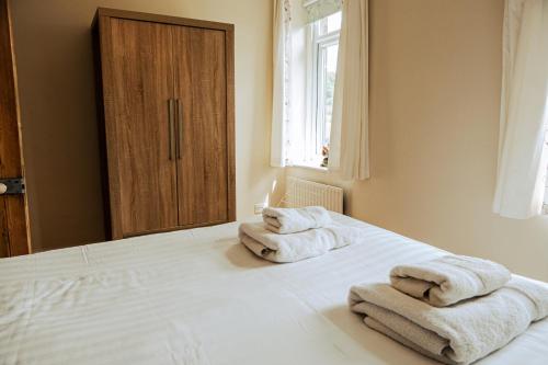 Matlock BankPainter's Cottage的卧室配有2条毛巾,位于床上