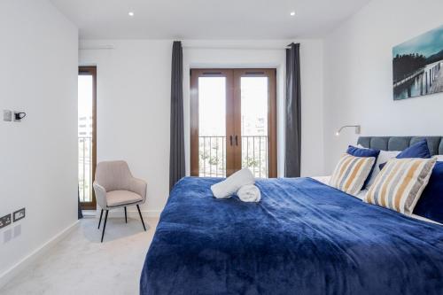 圣奥尔本斯Deluxe 1 Bedroom St Albans Apartment - Free Wifi的一间卧室配有蓝色的床和椅子