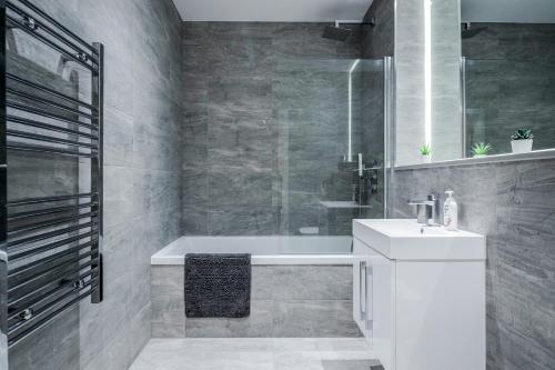 圣奥尔本斯Deluxe 1 Bedroom St Albans Apartment - Free Wifi的浴室配有白色水槽和浴缸。