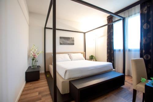 维贡扎Matrix Hotel & Residence的一间卧室,卧室内配有一张天蓬床