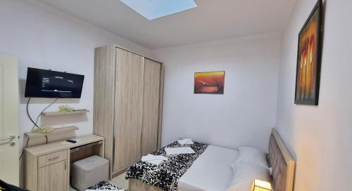 培拉特Downtown Apartment的一间带床和电视的小卧室