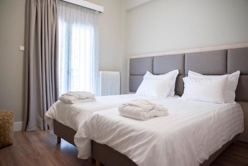 约阿尼纳CityScape Luxury Apartments的卧室配有带毛巾的大型白色床