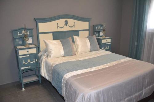 梅里达Apartamentos NayDa Gran casa con piscina的一间卧室配有一张带2个床头柜的大床