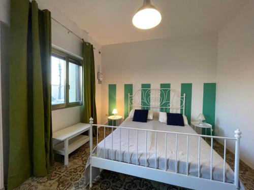 佩斯科勒海滨casa in spiaggia的一间卧室配有一张绿色和白色条纹的床