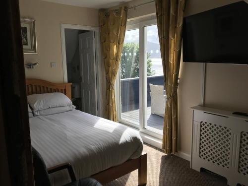 威廉堡堪波菲尔德酒店的一间卧室设有一张床和一个大窗户