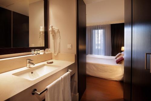 巴塞罗那康达多酒店的一间带水槽和床的浴室