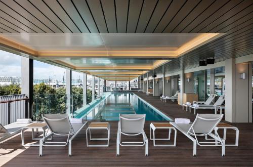 奥克兰Park Hyatt Auckland的酒店游泳池设有椅子和游泳池