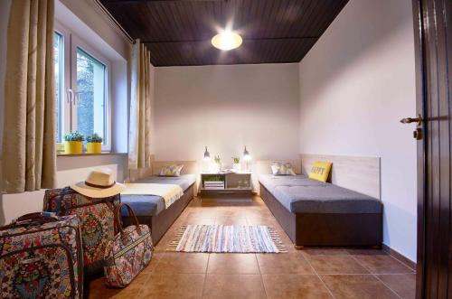 谢拉库夫Arenda Apartamenty&Domki całoroczne的客房设有两张床、椅子和桌子。
