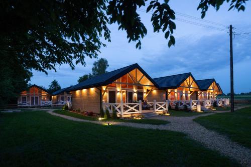 扎托尔Osada Zator Family Resort & SPA的夜晚一排带灯的小屋