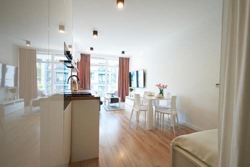 别尔斯克-比亚拉Apartament Dębowiec的厨房以及带桌椅的起居室。