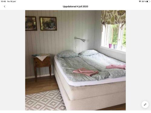 StråvallaStråvalla Hulegården的一间卧室配有带粉红色毛巾的床