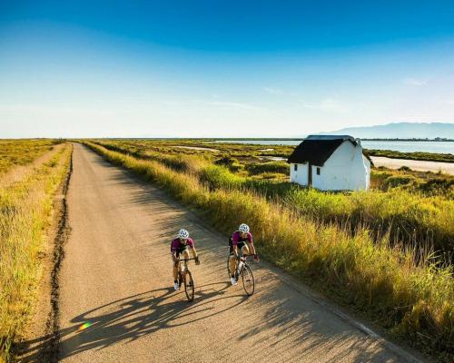 坎布里尔斯Casa bonmont con vistas al mar piscina y port aventura的两个人骑着自行车沿着土路走