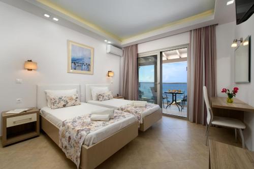 布卡里Villa Boukari Beach的一间带两张床和一张书桌的卧室以及一个阳台