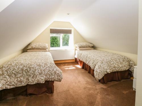 BeestonKeepers Cottage的阁楼间设有两张床,设有窗户