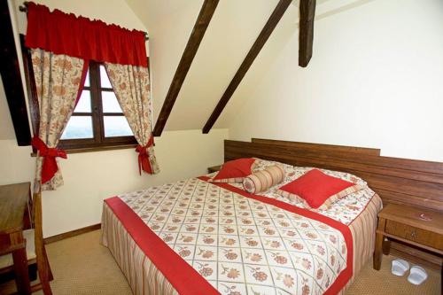 Hrašćina宝凡文斯基客房酒店的一间卧室配有一张带红色枕头的床和一扇窗户