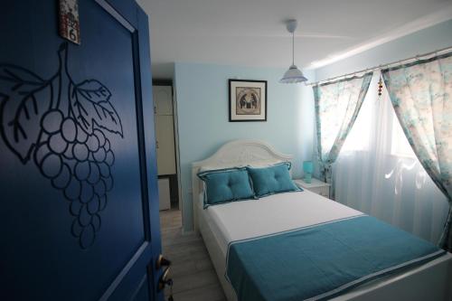 博兹贾阿达岛Nilada Bozcaada的一间卧室配有一张蓝色墙壁的床