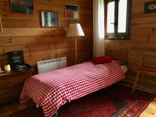 洪德莱斯Grand Pra的一间卧室配有一张带红 ⁇ 子毯子的床