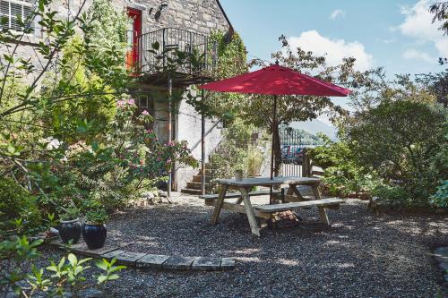 因弗雷里因弗雷里黑刺莓旅馆的一张带红伞和长凳的野餐桌