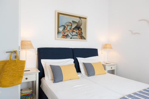 普拉提伊亚洛斯西弗诺斯NEFELI'S GUESTHOUSE IN PLATYS GIALOS SIFNOS的一间卧室配有黄色和白色枕头的床